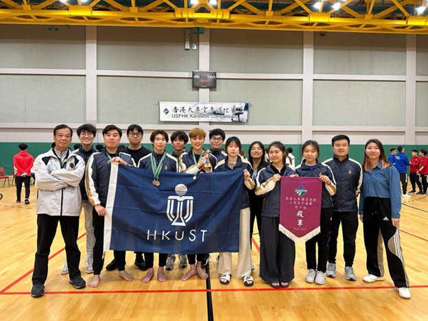 A group of people holding a bannerDescription automatically generated